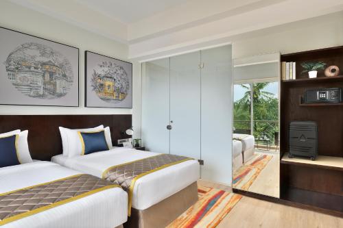 阿伯来Citadines Arpora Nagoa Goa的酒店客房设有两张床和电视。