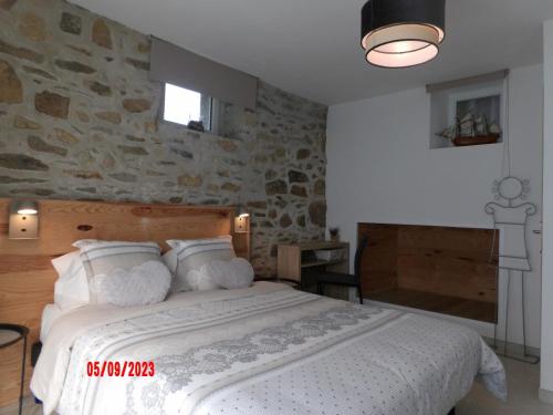 BégardLe cheval d’en fer的一间卧室设有一张带石墙的大床