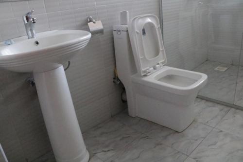 WoteParaiso Gardens Hotel的白色的浴室设有卫生间和水槽。