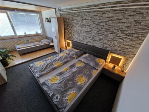 兹林ALICE酒店的一间卧室设有一张床和砖墙