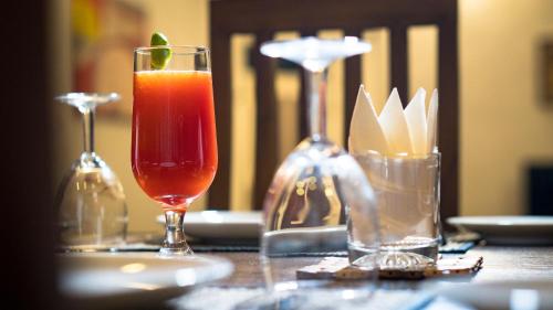 努沃勒埃利耶The Rosedale Grand Bungalow Nuwara Eliya的一张桌子,上面放着饮料和两杯眼镜