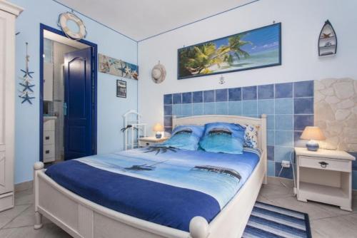 奥里亚Villa Jany- Adults only的一间卧室配有一张大床和蓝色瓷砖墙壁