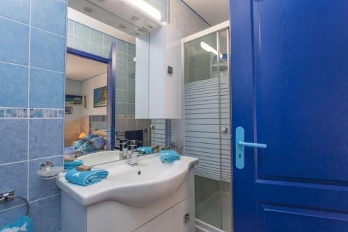 奥里亚Villa Jany- Adults only的一间带水槽和蓝色门的浴室
