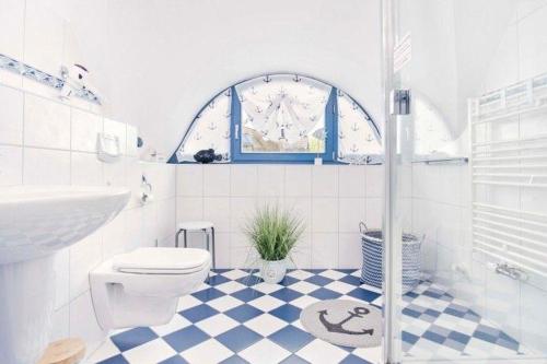 格洛韦Ferienhaus-Seehund的白色的浴室设有卫生间和水槽。