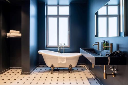 斯塔万格The Villa by Frogner House的蓝色的浴室设有浴缸和水槽