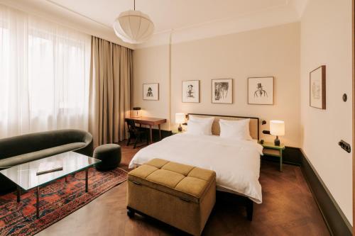 柏林Boutique Hotel Château Royal的一间卧室配有一张床、一把椅子和一张沙发
