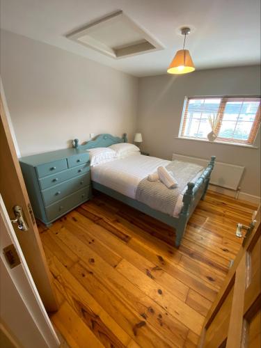 戈尔韦Cosy 4 Bedroom Galway House with Rear Garden Patio的一间卧室配有一张床,铺有木地板