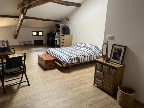 EspalaisLes chambres du Golf的一间卧室配有一张床,铺有木地板