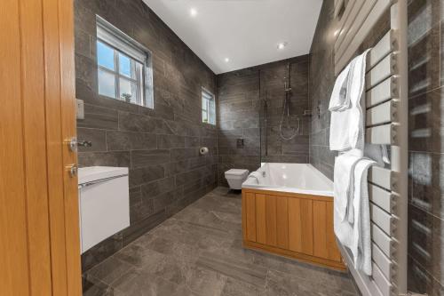 科尼斯顿Springbank Cottage, luxury Lake District cottage in Coniston的带浴缸、卫生间和盥洗盆的浴室