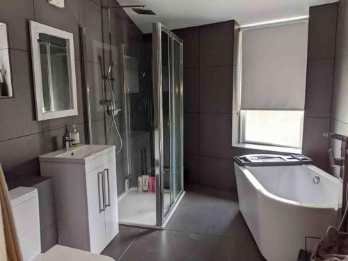纽基Central Newquay Terrace House的带淋浴、浴缸和盥洗盆的浴室