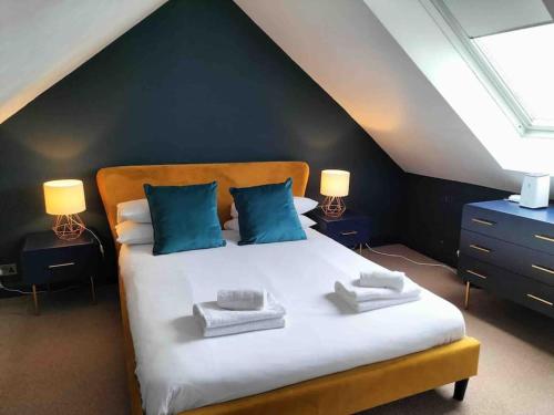 纽基Central Newquay Terrace House的卧室配有带蓝色枕头的大型白色床