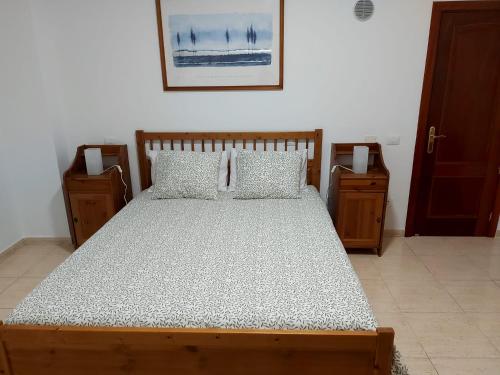 维辛达里奥NIVARIA SUITE的一间卧室配有木床和2个床头柜