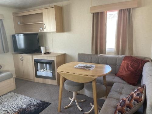 纽顿2 Bedroom Caravan - Ash 51, Trecco Bay的客厅配有沙发和桌子