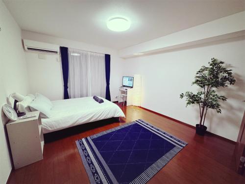 东京Brand New Shinjuku Station 5 Mins - Apartment D的一间卧室配有一张床和蓝色地毯