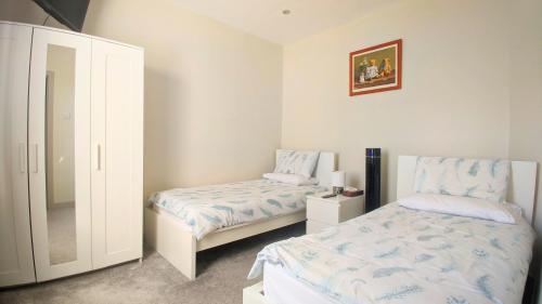 斯基普顿Modern holiday let in Skipton, North Yorkshire的一间卧室配有两张床和镜子