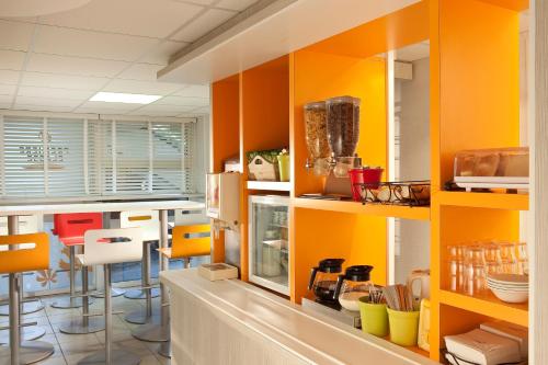 奥比埃普瑞米尔克雷蒙费兰德奥比耶尔经典酒店的厨房配有橙色和黄色橱柜