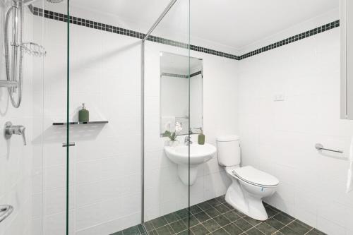 SylvaniaKing Bedroom Waterfront Courtyard Apartment的一间带卫生间和玻璃淋浴间的浴室