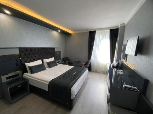 安卡拉alfin otel的酒店客房设有一张大床和一张书桌。