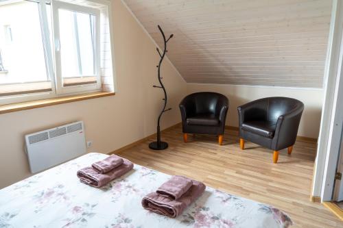 库雷萨雷Cosy Family Guesthouse with Sauna and Garden的一间卧室配有两张黑色椅子和一张床