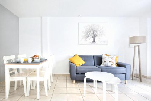 瑟堡La Saline - Second Souffle - Cherbourg的客厅配有蓝色的沙发和桌子