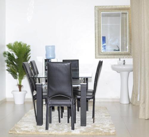 基苏木Sofitel Executive 3 bedrooms milimani的餐桌、黑色椅子和水槽