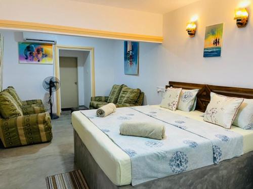希克杜沃阿卡迪亚度假村住宿加早餐旅馆的一间卧室配有一张大床和两把椅子
