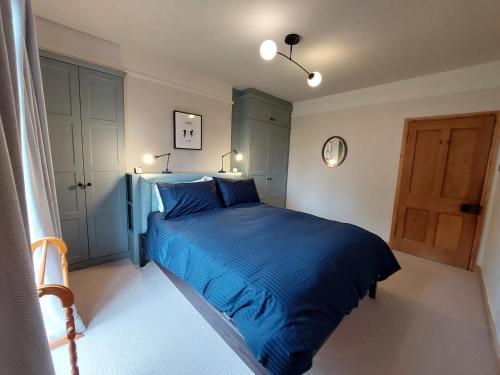因纳利森Cosy flat in Innerleithen的一间卧室设有蓝色的床和一扇门
