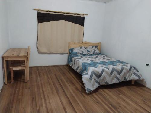 昆卡Terranova的一间卧室配有一张床和一张木桌