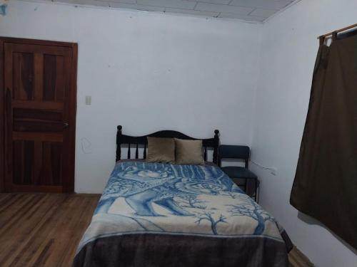昆卡Terranova的一间卧室配有一张带蓝白色毯子的床