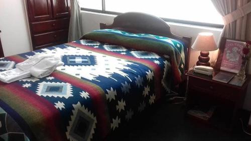 奥塔瓦洛Coraza Hotel的一间卧室配有一张带彩色毯子的床