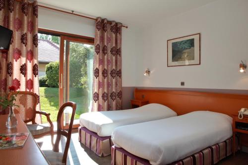 霍农LOGIS Le Pot D'Etain的酒店客房设有两张床和窗户。
