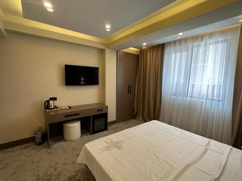 伊斯坦布尔Istanblu Hotel Ataşehir的酒店客房,配有床和电视