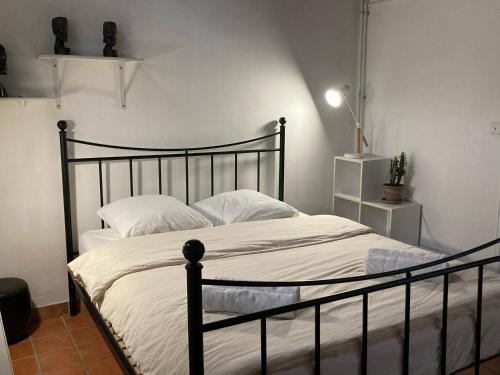 普罗旺斯艾克斯Le Cardinale - Un Voyage en Provence的一间卧室配有黑色床和白色床单