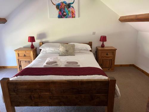 West HaddonWhite House Farm Cottages的一间卧室配有一张带2个床头柜的大床