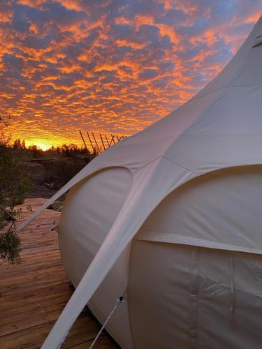 El RosarioLa Colmena Glamping的海滩上的帐篷,背面是日落