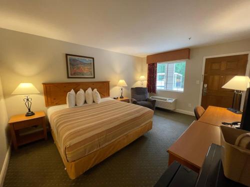 WoodvilleStagecoach Inn Woodville的酒店客房设有一张大床和一张书桌。