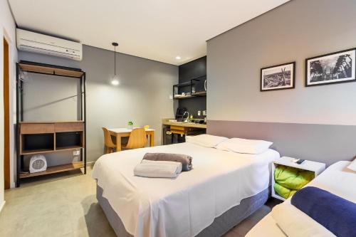 圣保罗Studio 2 Pinheiros by Oba的酒店客房配有两张床和一张书桌