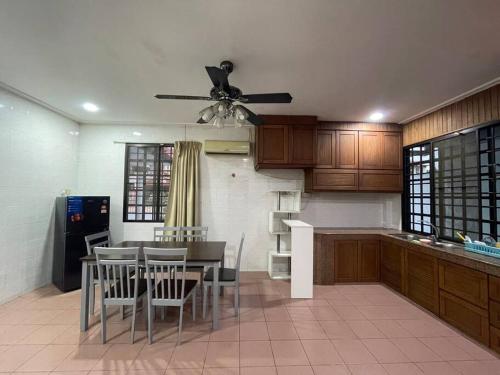 民都鲁Be My Guest Homestay Tjg Batu的厨房配有桌椅和吊扇。