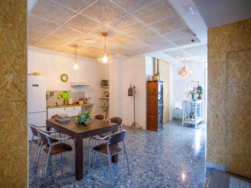 桑蒂蓬塞Italica Hostel的厨房以及带桌椅的用餐室。