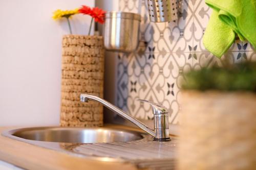 桑蒂蓬塞Italica Hostel的厨房水槽设有水龙头和花瓶