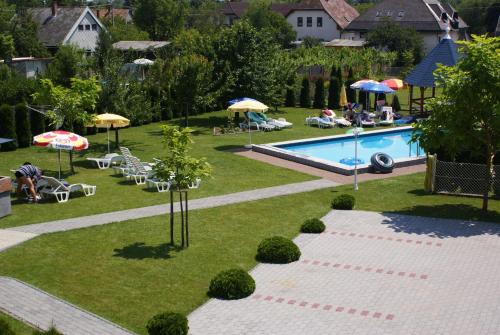 根尼斯迪亚斯Kék Vendégház Family Resort的享有带遮阳伞和椅子的游泳池的顶部景致