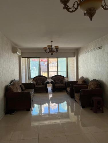 纳布卢斯Salah Khamlan Apartments的带沙发和吊灯的大型客厅