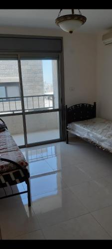 纳布卢斯Salah Khamlan Apartments的客房设有两张床和大窗户。