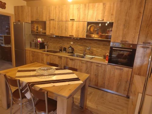 弗洛里纳Villa Stella的厨房配有木制橱柜、桌子和水槽。