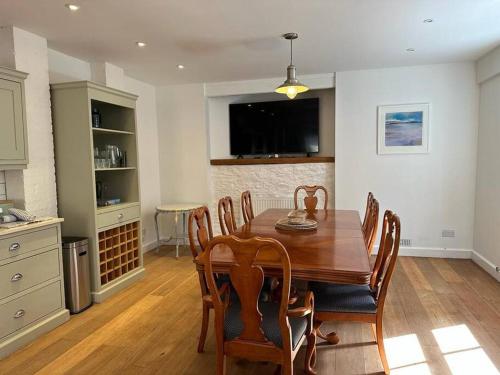 达特茅斯Home in Dartmouth, Devon with Private Parking的一间带木桌和椅子的用餐室
