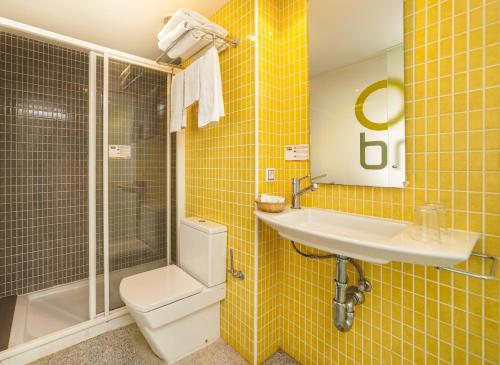 埃尔阿雷纳尔巴伊亚皇家酒店的黄色瓷砖浴室设有水槽和卫生间