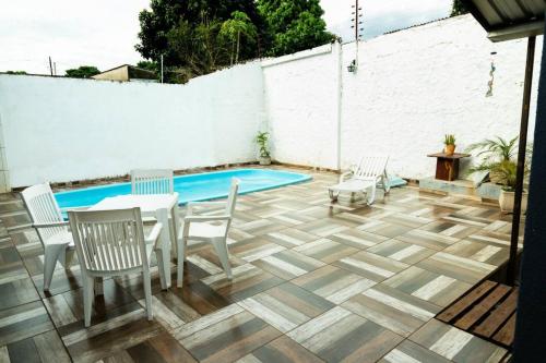 伊瓜苏Casa na Fronteira的一个带桌椅的庭院和一个游泳池