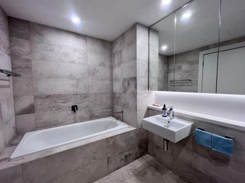 悉尼High Level Fabulous View 4Beds APT in Olympic Park的浴室配有白色浴缸和水槽