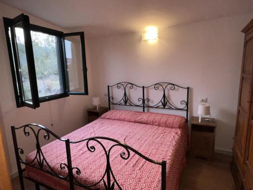 奇亚Casa Chia a 5 minuti dal mare - Su Giudeu Tuerredda的一间卧室配有一张带红色床罩的床和窗户