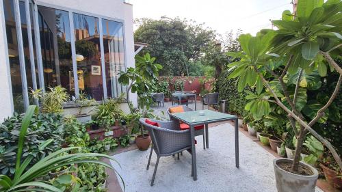 阿格拉Ekaa Villa near Taj Mahal的庭院配有桌椅和植物
